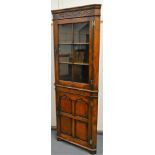 A 20thC Stanley Cumper oak freestanding corner drinks cupboard, with a carved top raised above a