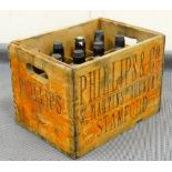 A vintage Phillips & Co bottle crate, containing twelve vacant green glass bottles with Phillips &