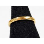 A textured band, marked 18ct, size L.