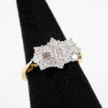 A floral set dress ring, with baguette cut white stones, surrounded by small claw set stones, on a