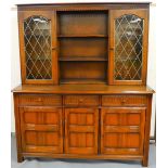 A 20thC Ercol dark wood display cabinet, with moulded frieze raised above open shelves flanked by