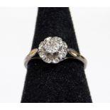 An illusion set diamond dress ring, with floral arrangement on part pierced shank, marks pitted,