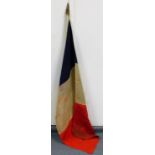 An early 20thC French flag, on a turned partially stained pole, with shaped finial, 141cm high.