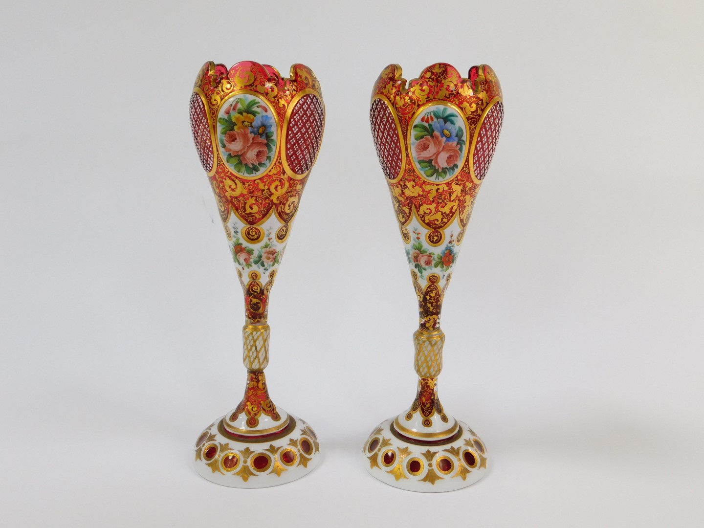 A pair of late 19thC Bohemian flashed cranberry glass vases, of ogee form, raised on a