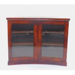 A Regency flame mahogany concave display cabinet, with two glazed doors, opening to reveal two