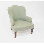 A Victorian mahogany nursing chair, upholstered in button back green patterned fabric, raised on