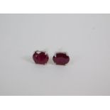 A pair of silver and oval cut ruby solitaire earrings, 3.54ct, with certificate.