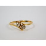 An 18ct gold and diamond two stone ring, in a crossover setting, approx 1/4 carat, size N, 2.0g.