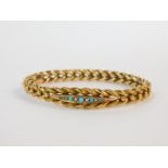 A 9ct gold seed pearl and turquoise set bangle, on a snap clasp with safety chain as fitted, 10.3g.
