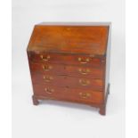 A George III oak bureau, the fall flap opening to reveal a central door, drawers and recesses,