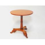 An Empire style burr elm and mahogany cross banded occasional table, the circular top raised on