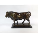 A bronze cast figure of a bull, modelled in standing pose, on a rectangular base, raised on a