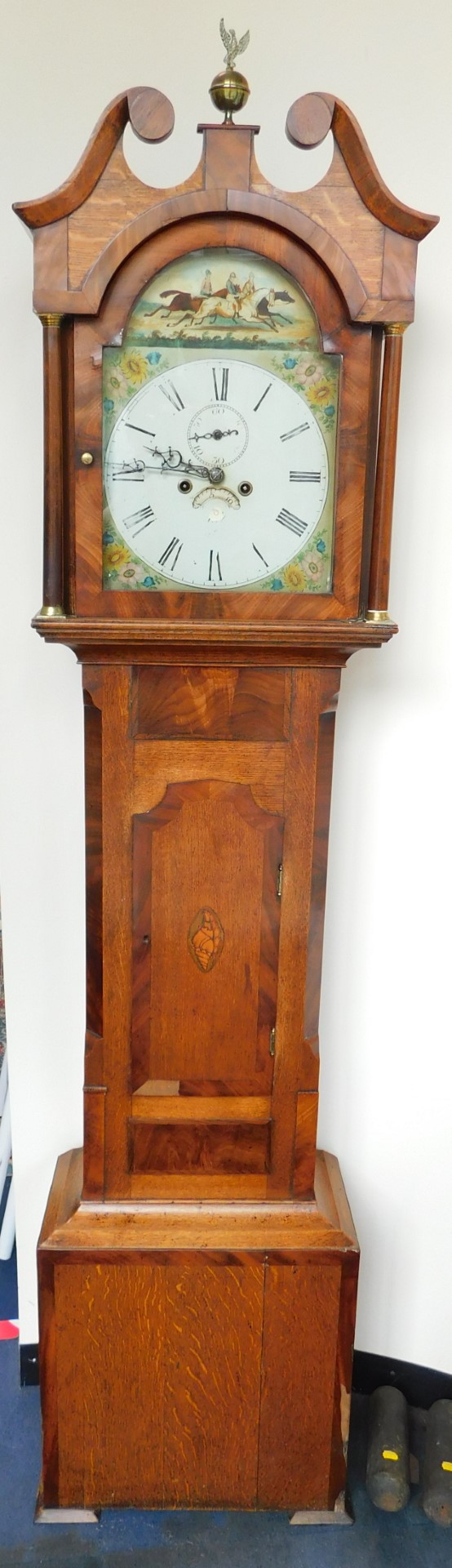 A George III oak and mahogany long case clock, the break arch dial painted with a horse race and