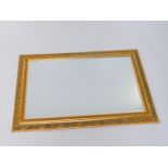 A gilt wood wall mirror, with foliate fret work decoration, inset bevelled glass, 105cm W, 75cm D.