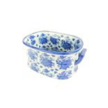 A reproduction blue and white pottery foot bath, printed in blue and white with sprays of flowers,