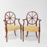 A pair of early 20thC Hepplewhite style mahogany wheel back carver chairs, with pigskin leather