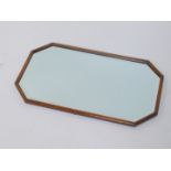 A mid 20thC oak wall mirror, of octagonal form, inset bevel glass, 14.5cm wide, 68cm high.