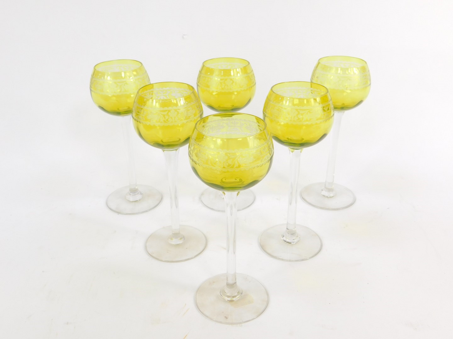 A set of six 20thC French apple green high stem wine glasses, etched with a band of fleur de lys and