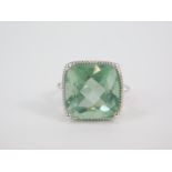 A silver and Tucson teal green fluorite ring, the cushion shaped fluorite in a high claw setting,