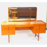 A Merrydew teak 1960's dressing table, with a tryptic backed mirror, over a cushion drawer flanked