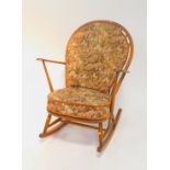 An Ercol beech and elm dark stained Windsor rocking chair, with a loose cushion seat and back.