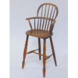 A 19thC oak and elm child's Windsor high chair, raised on turned legs, united by an H frame