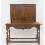A 17thC and later oak side table, with a paneled splash back, carved frieze with single frieze