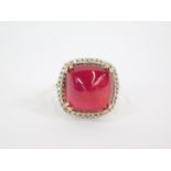 A 9ct gold Malagasy ruby and zircon Tomas Rae ring, the cushion shaped ruby in a surround of