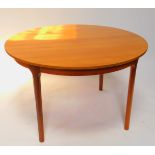 A Johannes Andersen Danish circular teak dining table, with one additional leaf, raised on turned