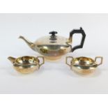 A George V silver three piece tea set, of compressed cylindrical form, comprising teapot, cream