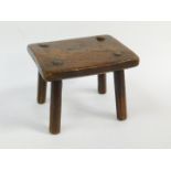 A Welsh 19thC elm stool, with a rectangular top raised on four turned legs, 23cm wide, 18cm deep,
