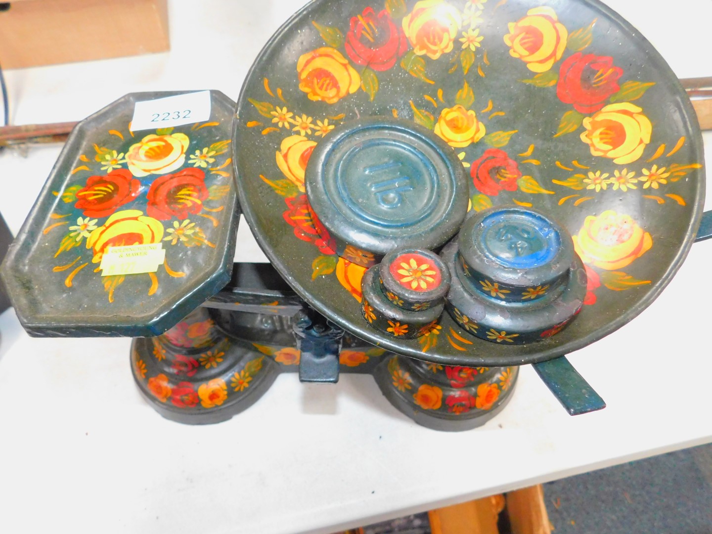 A bargeware set of kitchen scales, decorated with flowers, with similarly decorated weights.