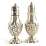 A pair of late Victorian small pepper pots, each with embossed C scroll decoration, Birmingham 1897,