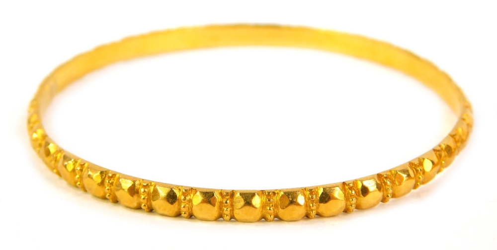 A pair of circular bangles, with faceted decoration, unhallmarked yellow metal. - Image 2 of 2