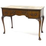 An early 20thC mahogany bow fronted writing table, the top with a brown leather inset, above an