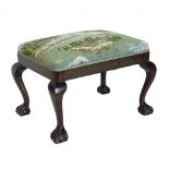 A mahogany stool in George III style, with padded seat on cabriole legs with ball and claw feet.