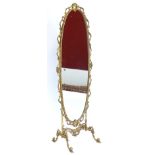 A gilt metal cheval mirror, the oval frame decorated with shells, scrolls, etc., on shaped supports,