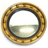 A gilt gesso circular convex wall mirror, with ebonised reeded slip, 42.5cm diameter.