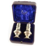 A pair of Edwardian silver sugar castors, each of baluster form, the lid with Howard decoration,