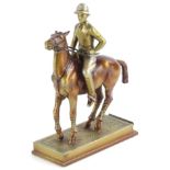 A cold painted spelter figure of a polo player on horseback, on a rectangular base, with a slot