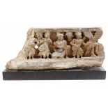 A Gandhara 2nd Century carving, formed as figures aside tree, on an ebonised plinth base,