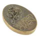 A bronze plaque or paperweight, dedicated to the war poet Wilfred Owen (1893-1918), cast with a