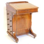 A late Victorian walnut and boxwood Davenport, the top with a raised gallery and hinged slope