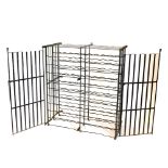 A Country House type wrought iron wine rack, of slatted form with two doors enclosing shaped