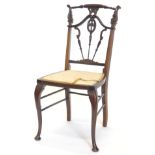 An Edwardian mahogany side chair, the back carved with C scrolls, flowers, etc., with turned