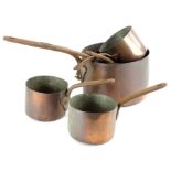 A collection of copper saucepans, each with silvered interior and a shaped iron handle, various