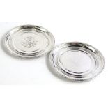 A pair of Georg Jensen silver dishes, each decorated with fruit on a hammered ground, with beaded