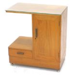 An Art Deco teak side cabinet, the rectangular top above a cupboard, flanked by a recess and a