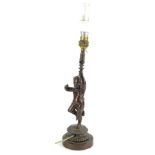 A 19thC bronze lamp base, modelled in the form of a putto, holding the fitting on a circular base,