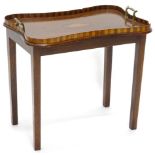 A mahogany tray table, the top with a raised checkered gallery, two brass handles and a central oval